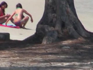 Somebody spying on two sexy babes are sun tanning on beach